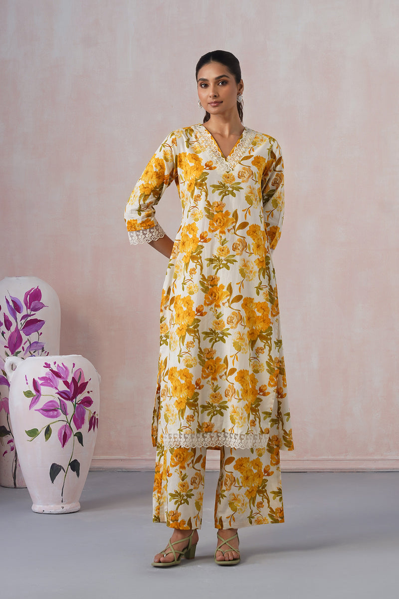 Woman wearing a yellow floral dress with a plain background